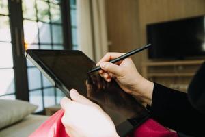 Reifer Geschäftsmann, der ein digitales Tablet verwendet, um Informationen mit einem jüngeren Kollegen in einer modernen Business-Lounge zu besprechen foto