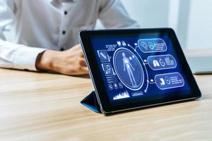 digitales mobiles tablet mit digitalem symbolhologramm und medizinischem grafikdiagramm auf dem bildschirm mit patienten im krankenhaus, coronavirus, medizintechnik, gesundheitskrebs und krankheitsbehandlungskonzept foto