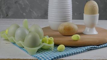 Ostern Küchendesign. Stillleben mit Eiern und einem Küchenholzbrett auf weißem Hintergrund. Vordergrund. Platz kopieren foto