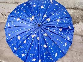 blauer Regenschirm mit Puppenmotiv foto