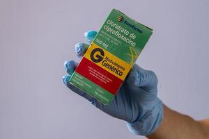 rio, brasilien - 27. januar 2023, hand mit schützendem gummihandschuh, der medikamentenbox hält, cipofloxacinhydrochlorid foto