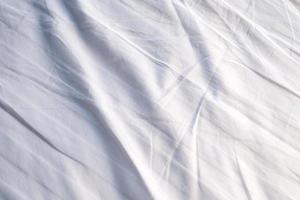 weiße bettwäscheverlaufsstruktur verschwommener kurvenstil aus abstraktem luxusstoff, zerknitterter bettwäsche und dunkelgrauen schatten, hintergrund foto