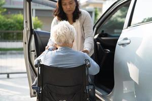 asiatische senior oder ältere alte damenpatientin, die im rollstuhl sitzt, bereiten sich auf ihr auto vor, gesundes starkes medizinisches konzept. foto