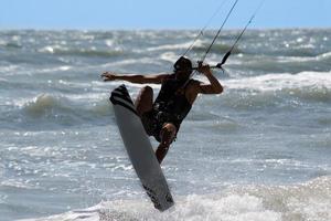 Kitesurfer springt und fliegt hoch foto