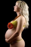 schwangere junge Blondine mit roter Blume. isoliert foto
