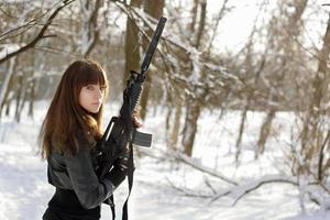 bewaffnete Frau im Winterwald foto