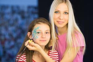 hübsche blonde frau, die gesichtskunst macht foto