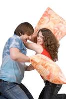 Das junge Paar kämpft um Kissen. isoliert foto
