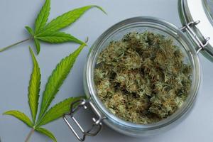 Cannabis in der Draufsicht des Glases, Marihuana-Blatt im Hintergrund. die medizinische Verwendung im Gesundheitswesen foto