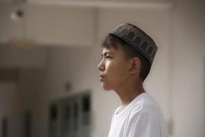 Porträt eines südostasiatischen muslimischen Jungen in weißem Hemd und Hut, weicher und selektiver Fokus. foto