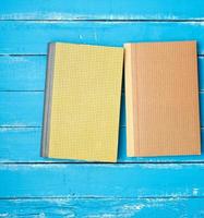 zwei geschlossene Hardcover-Bücher auf blauem Holzhintergrund foto