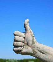 Ein männlicher Finger hob sich gegen den blauen Himmel, eine anerkennende Geste foto