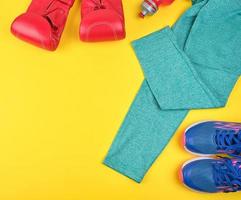 Paar blaue Turnschuhe, rote Boxhandschuhe aus Leder foto