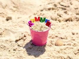 rosa babyeimer mit sand und aufschrift sommer foto