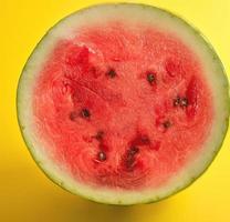 halbrunde reife rote Wassermelone mit braunen Samen foto