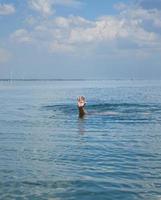 Hand ragt mitten im Ozean aus dem Wasser foto