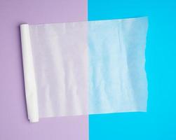 abgewickeltes weißes Pergament-Backpapier auf einem blauvioletten Hintergrund foto