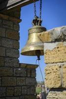 eine Kupferglocke, die an einer Kette in einem Glockenturm hängt foto