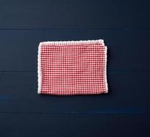 weiß rot kariertes Küchentuch auf blauem Holzhintergrund foto