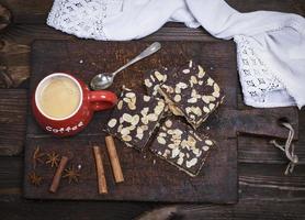 Kaffee mit Schaum in einem roten Keramikbecher auf dem Küchenschneidebrett foto