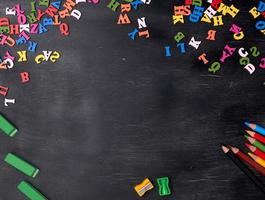 Mehrfarbige kleine Holzbuchstaben des englischen Alphabets auf einer schwarzen Kreidetafel foto