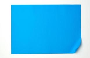leeres blaues Blatt Papier mit einer abgerundeten Ecke auf weißem Hintergrund foto