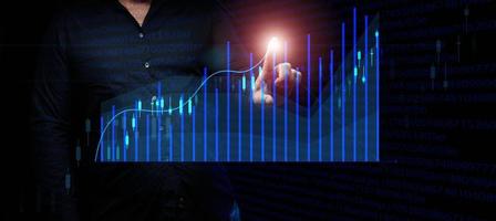 geschäftsmann im anzug steht vor einem holografischen diagramm mit wachsenden zahlen, geschäftswachstum, hohem einkommen. Handel an der Börse foto