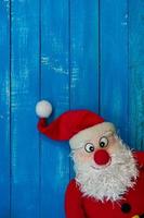 Weihnachtsweihnachtsmann auf einem blauen Hintergrund aus Holz foto