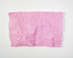 zerknittertes rosa rechteckiges Blatt Papier auf weißem Hintergrund foto
