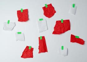 viele zerrissene rote und weiße papierstücke, die mit grünem klebeband verklebt sind foto