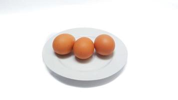 braune Hühnereier auf weißem Teller isoliert auf weißem Hintergrund foto