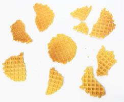 Gebackene runde belgische Waffeln auf weißem Hintergrund, Scherben und Krümel foto