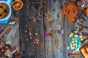 Süßigkeiten und schwarzer Kaffee auf einer grauen Holzoberfläche foto