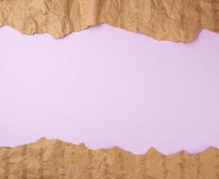 abstrakter lila hintergrund mit braunen zerrissenen papierelementen foto