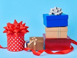 Stapel verpackter Geschenke mit geknoteten Schleifen auf blauem Hintergrund foto