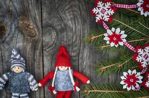 weihnachtshintergrund mit geschmücktem tannenzweig und textilspielzeug foto