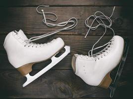 alte weiße Damenschlittschuhe für Eiskunstlauf mit ungebundenen Schnürsenkeln foto