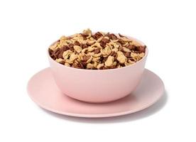 Schokoladen- und Honigcornflakes in rosa Platte auf weißem Hintergrund. Morgenfrühstück mit Milch foto