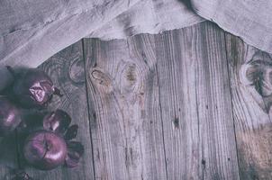 Vintage grauer Hintergrund aus Holz mit roten Zwiebeln foto