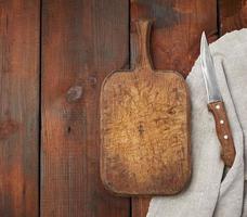 Sehr altes leeres rechteckiges Holzschneidebrett und Messer, Draufsicht foto
