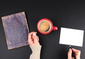 rote Sahnetasse mit schwarzem Kaffee, weibliche Hände foto