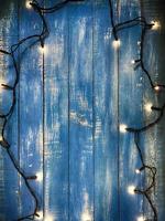 Elektrische Girlande mit kleinen Pfoten auf blauem Holzhintergrund foto