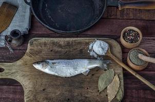 Gefrorener Fisch roch auf einem Küchenschneidebrett foto