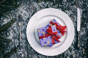 Weihnachtsgeschenke auf dem weißen Teller foto