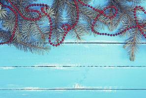 grüne Fichtenzweige mit einer roten Weihnachtsgirlande foto
