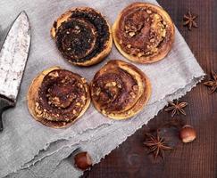 Runde Brötchen mit Zimt und Mohn auf einer grauen Textilserviette foto