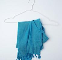 Blauer Textilschal, der an einem weißen Metallbügel hängt foto
