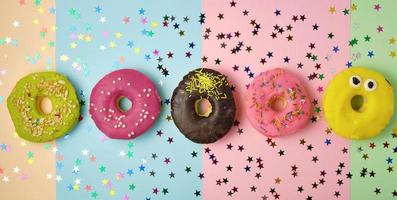 fünf runde Donuts mit verschiedenen Füllungen und Streuseln foto
