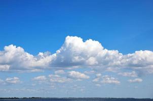 Blick auf das Meer mit Windmühlen in der Ferne foto