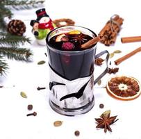 Glühwein in einem Glas auf weißem Holzhintergrund foto